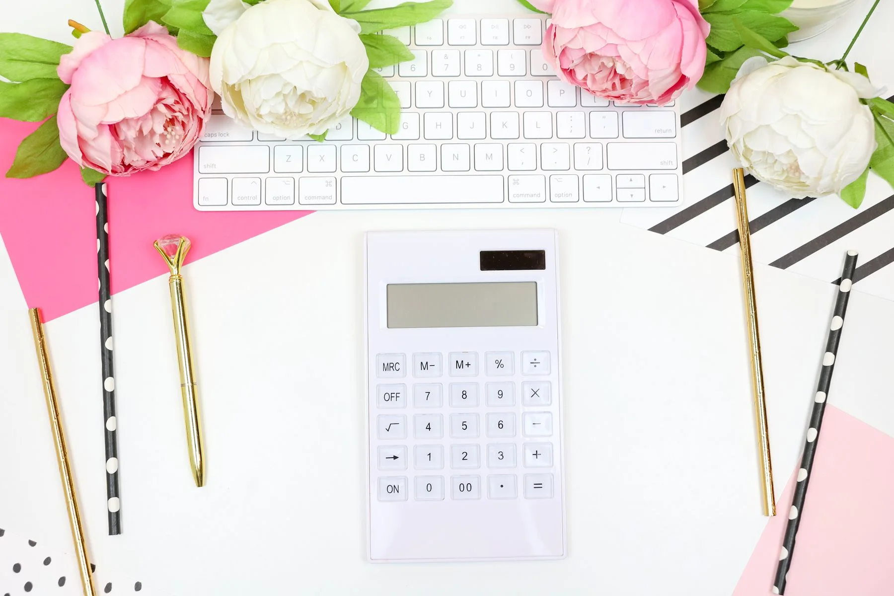 Calculator, notebook and flowers used to plan a wedding budget