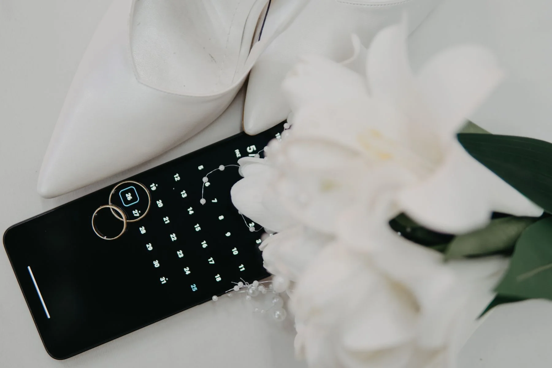 Wedding rings arranged on elegant stationery with flowers